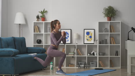 young-woman-with-ponytail-is-doing-squats-at-home-training-alone-in-living-room-at-weekend-healthy-and-sporty-lifestyle-full-lenght-shot